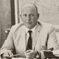 man sits at a desk looking at the camera