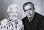 a woman and man sit looking at the camera smiling