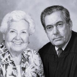 a woman and man sit looking at the camera smiling