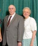 Dr. Richard and Patricia Petre stand next to each other in front of a green backdrop