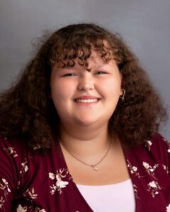 Headshot of a teenaged girl smiling at the camera.