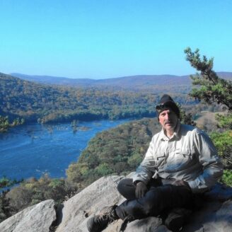 Man atop rock in the mountains