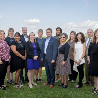 A group of professionals pose for an outdoor photo.