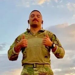 man in military attire giving a thumbs up