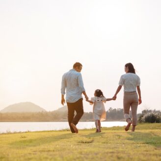 family walking in the park at sunset