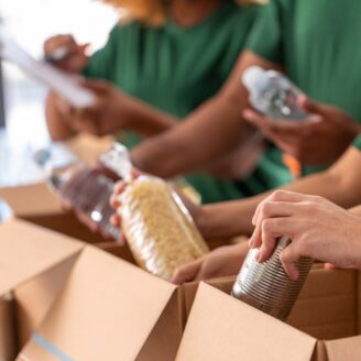 People packing food into cardboard boxes