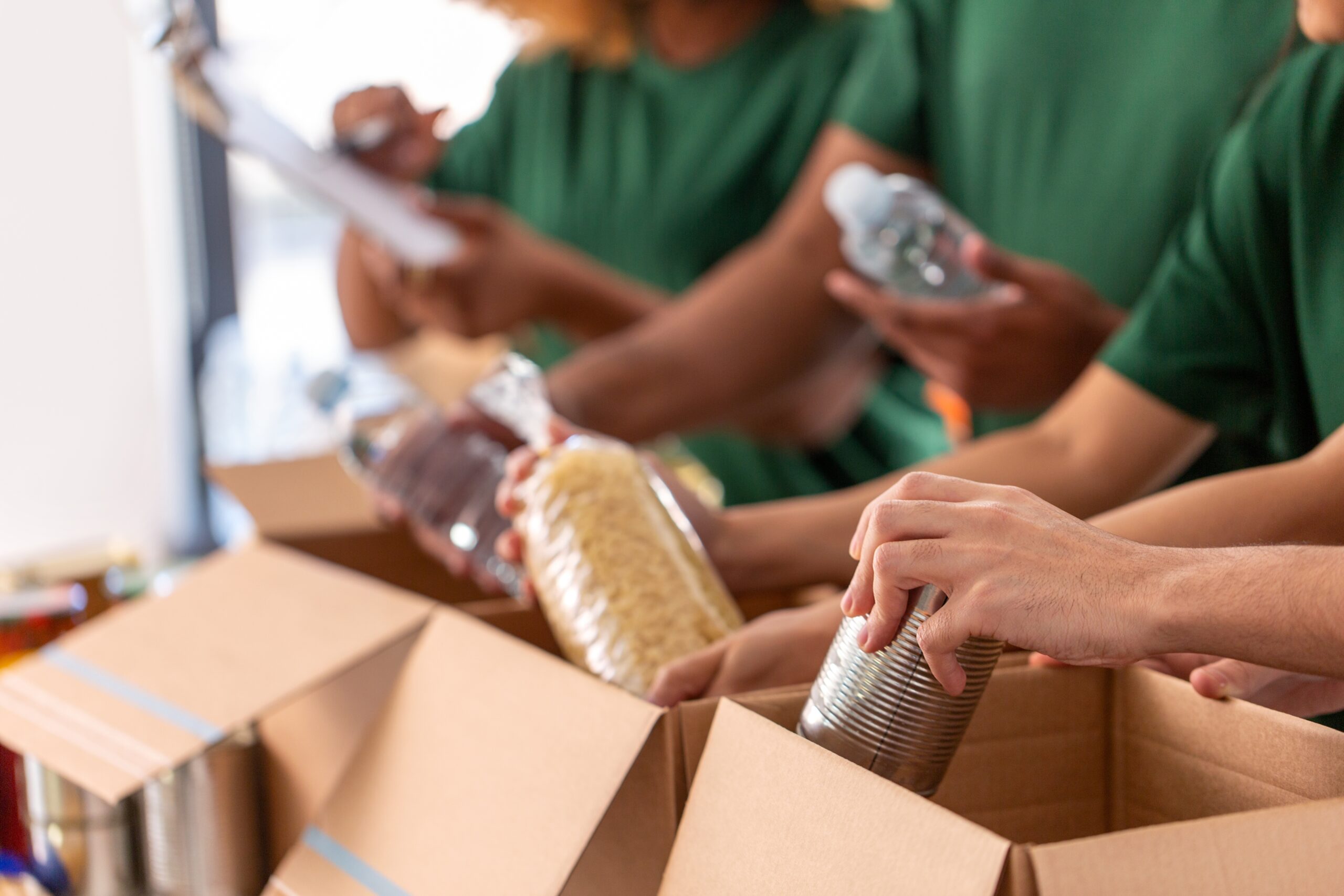 People packing food into cardboard boxes