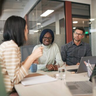 meeting with three people at a conference table