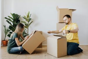 Two people packing moving boxes.