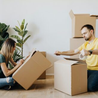 Two people packing moving boxes.