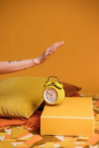Hand reaching to shut off alarm clock.
