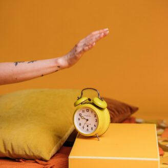 Hand reaching to shut off alarm clock.