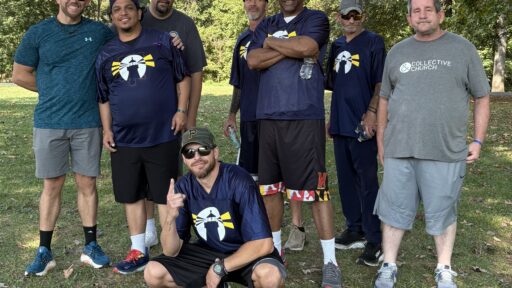 A group of men from The Rescue Mission Changed Life Recovery Program stand smiling at the camera