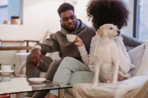 people sitting on couch with dog