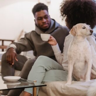 people sitting on couch with dog